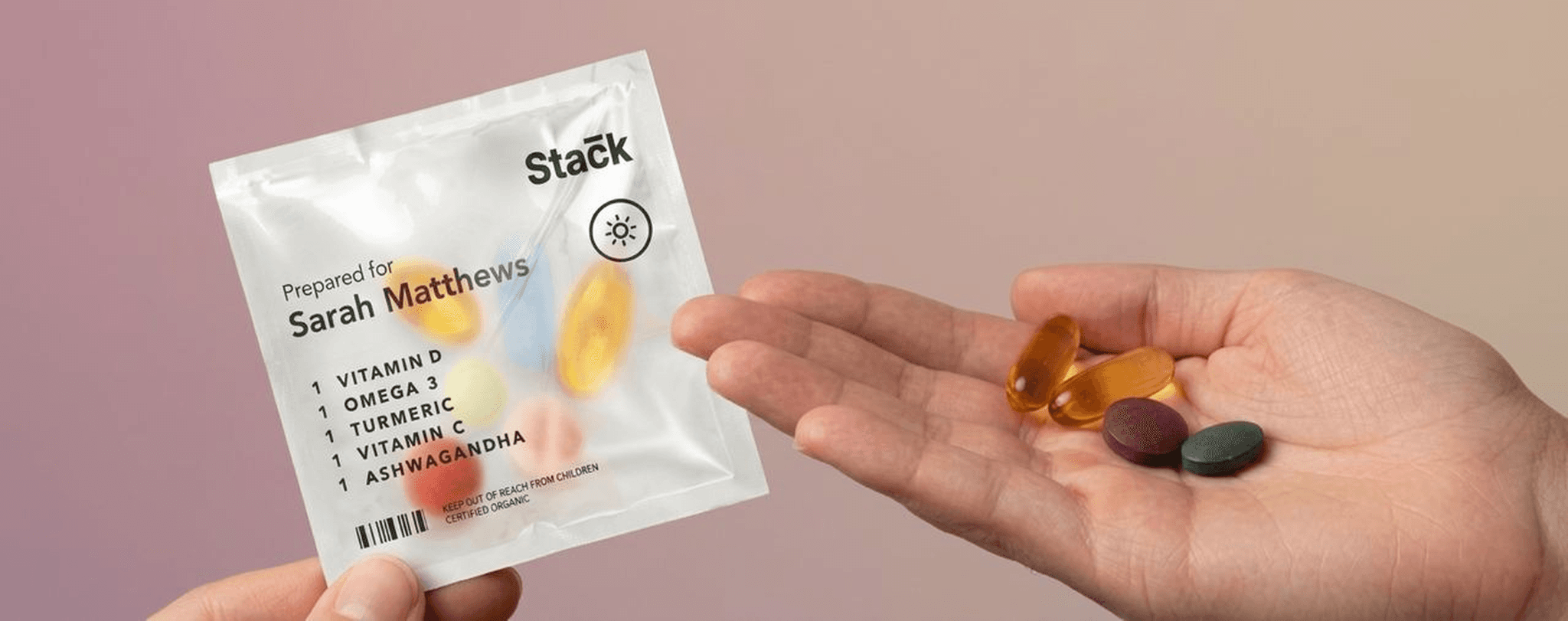 Hands holding Stack sachet and supplement pills
